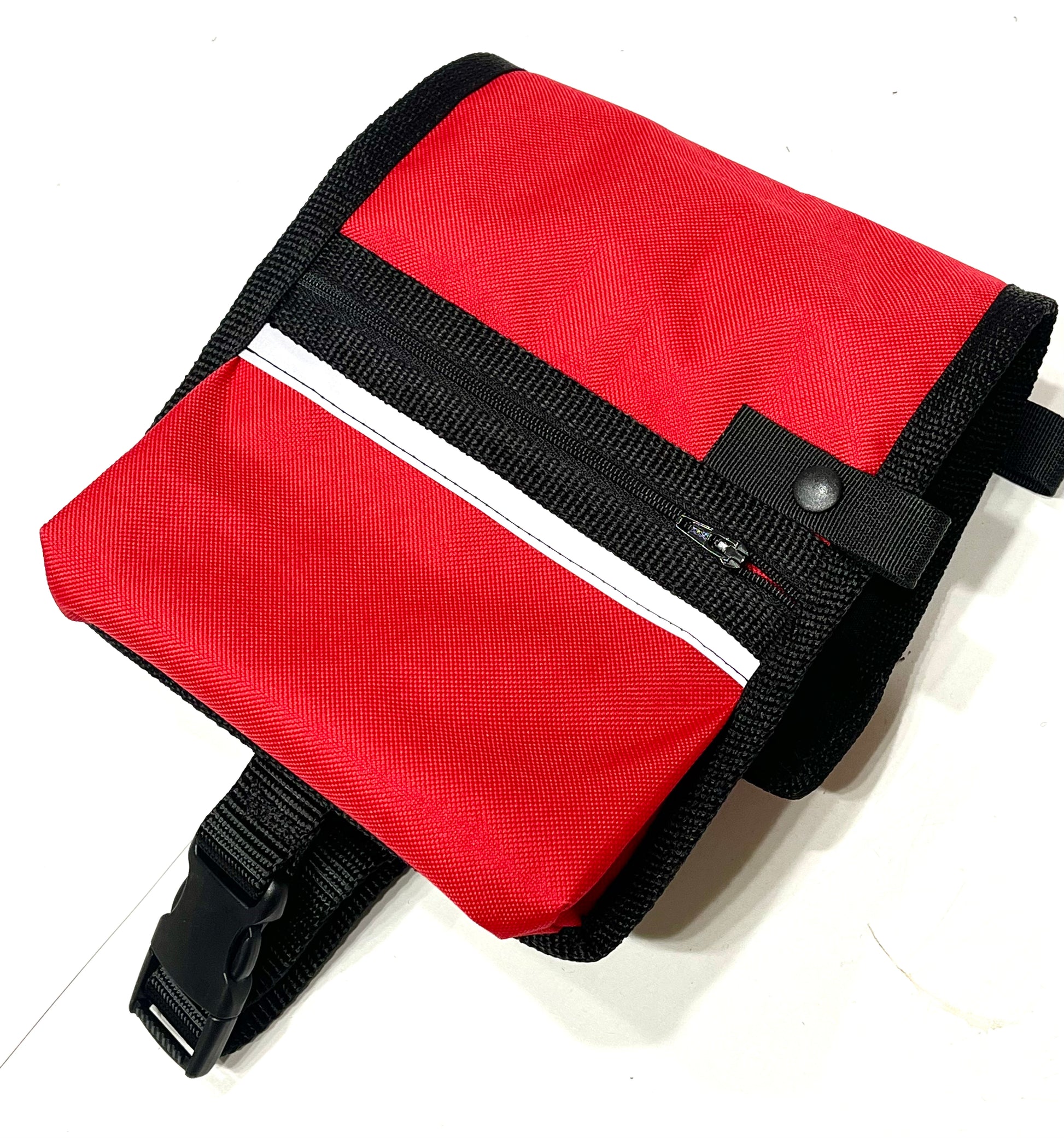 a bright red dog cape with zippered pockets, black bonding and silver reflective strips 